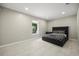 Modern bedroom featuring tile floors, a large window and a sleek, dark-framed bed at 6665 Lake Cane Dr, Orlando, FL 32819