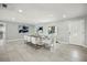Dining room area featuring white tile floor, modern table with white leather chairs and front door at 6665 Lake Cane Dr, Orlando, FL 32819