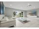 Bright living room featuring a white sofa, tile floors and a view of the lake and pool at 6665 Lake Cane Dr, Orlando, FL 32819