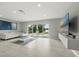 Open-concept living room with white tile flooring and sliding glass doors to the pool at 6665 Lake Cane Dr, Orlando, FL 32819