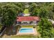 Aerial view of a house with a beautiful rectangular in-ground pool and brick pool deck, surrounded by trees at 6665 Lake Cane Dr, Orlando, FL 32819