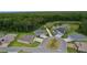 Beautiful aerial view of homes surrounding a pond with lush greenery and landscaping at 6991 Sugar Creek Path, The Villages, FL 34762