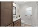Cozy bathroom with white countertop vanity, wood cabinets, and toilet at 6991 Sugar Creek Path, The Villages, FL 34762