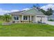 Charming one-story home with a well-kept lawn and flowerbeds, featuring a cozy seating area on the porch at 6991 Sugar Creek Path, The Villages, FL 34762