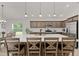 Kitchen island featuring barstool seating, pendant lighting, and a view into the connected dining and kitchen space at 6991 Sugar Creek Path, The Villages, FL 34762