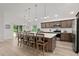 Kitchen island with seating, ample counter space, stainless appliances and an open layout to dining and living areas at 6991 Sugar Creek Path, The Villages, FL 34762