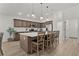 Open kitchen with a large island, stainless steel appliances, and wood cabinets at 6991 Sugar Creek Path, The Villages, FL 34762