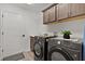 Modern laundry room featuring a new washer, a new dryer and cabinets at 6991 Sugar Creek Path, The Villages, FL 34762