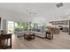 Spacious living room with cozy seating, a view of the backyard, and an open layout to the kitchen at 6991 Sugar Creek Path, The Villages, FL 34762
