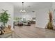 Open-concept living room flowing into the kitchen and dining area with lots of natural light at 6991 Sugar Creek Path, The Villages, FL 34762