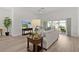 Bright living room with a comfortable sofa, stylish furnishings, and a view of the outdoor patio at 6991 Sugar Creek Path, The Villages, FL 34762