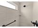 Modern shower with neutral tile, window and black fixtures at 6991 Sugar Creek Path, The Villages, FL 34762