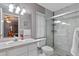 Bright bathroom with white vanity, updated lighting, and a glass-enclosed shower with tiled walls at 815 Forestwood Dr, Minneola, FL 34715