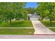 Well-maintained single-story home with green lawn, mature trees, and a two-car garage at 815 Forestwood Dr, Minneola, FL 34715