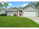 Charming single-story home featuring a well-manicured lawn and a bright red front door at 815 Forestwood Dr, Minneola, FL 34715