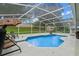 Enclosed pool area with seating, view of the backyard, and surrounded by a screened enclosure at 815 Forestwood Dr, Minneola, FL 34715
