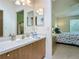 Well-lit bathroom with a modern vanity, framed mirror, and seamless access to the main bedroom at 8195 Se 174Th Rowland St, The Villages, FL 32162
