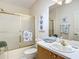 Bathroom featuring a tub and shower with gold frame and hardware, a single vanity, and artwork at 8195 Se 174Th Rowland St, The Villages, FL 32162