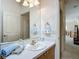 Bright bathroom featuring a single vanity with framed mirror and blue accents; a door leads to another room at 8195 Se 174Th Rowland St, The Villages, FL 32162