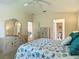 Bright bedroom showcasing a sea-inspired comforter, dresser, and doorway views to a bathroom and living area at 8195 Se 174Th Rowland St, The Villages, FL 32162
