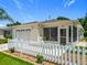 Charming home with a white picket fence, attached garage, and screened-in porch at 8195 Se 174Th Rowland St, The Villages, FL 32162