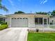 Home exterior with a garage, a screen porch, a white picket fence and a well-manicured lawn at 8195 Se 174Th Rowland St, The Villages, FL 32162