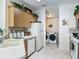 Bright kitchen featuring tile flooring, white appliances, and ample cabinet space with greenery at 8195 Se 174Th Rowland St, The Villages, FL 32162