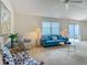 Comfortable living room with blue sofa, patterned chairs, and sliding glass doors at 8195 Se 174Th Rowland St, The Villages, FL 32162