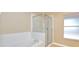 Bathroom with a glass shower, tub, and white tiling at 832 Willow Run St, Minneola, FL 34715