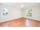 Bright bedroom with hardwood floors and two windows at 832 Willow Run St, Minneola, FL 34715