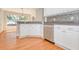 Bright kitchen features white cabinets, stainless steel dishwasher, and hardwood floors at 832 Willow Run St, Minneola, FL 34715