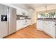 Functional kitchen featuring white cabinets, stainless steel appliances, and neutral tile backsplash at 832 Willow Run St, Minneola, FL 34715