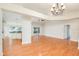 Spacious open living space showcasing wood floors, high ceilings, kitchen, and backyard access at 832 Willow Run St, Minneola, FL 34715