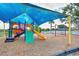 Community playground shaded by a canopy, featuring slides and swings at 832 Willow Run St, Minneola, FL 34715