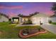 Inviting home with manicured lawn, landscape lighting, and a charming front porch at 8537 Se 177Th Bartram Loop, The Villages, FL 32162