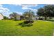 Home featuring a well-manicured lawn with mature trees and landscaping at 8537 Se 177Th Bartram Loop, The Villages, FL 32162