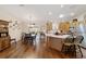 Open-concept kitchen and dining area featuring hardwood floors and updated stainless steel appliances at 8537 Se 177Th Bartram Loop, The Villages, FL 32162
