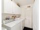 Bright laundry room with modern washer and dryer units, ample cabinet space, and convenient layout at 8537 Se 177Th Bartram Loop, The Villages, FL 32162