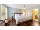 Spacious main bedroom featuring a king bed, wood floors, ceiling fan, and an ensuite bathroom at 8537 Se 177Th Bartram Loop, The Villages, FL 32162