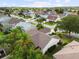 A high aerial shot of a residential neighborhood with palm trees, green lawns and mature landscaping at 891 Lucky Ln, The Villages, FL 32162