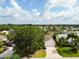 An aerial of the home in a beautiful neighborhood with lush green trees and landscaping at 891 Lucky Ln, The Villages, FL 32162