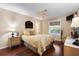 Comfortable bedroom with natural light from the window, plus ceiling fan and hardwood floors at 891 Lucky Ln, The Villages, FL 32162