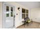 Cozy entryway with a chair, shutters and natural light coming through the glass paneled front door at 891 Lucky Ln, The Villages, FL 32162