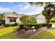 Charming single-story home with manicured landscaping, a two-car garage, and a red awning at 891 Lucky Ln, The Villages, FL 32162