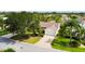 An aerial view of the home, highlighting its mature landscaping, long driveway, and well-manicured lawn at 891 Lucky Ln, The Villages, FL 32162