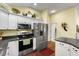 Bright kitchen with stainless steel appliances and light countertops, and hardwood floors at 891 Lucky Ln, The Villages, FL 32162