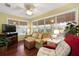 Cozy sunroom featuring hardwood floors, many windows, and comfortable seating at 891 Lucky Ln, The Villages, FL 32162