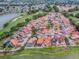 A captivating aerial view of a residential neighborhood situated alongside a lush golf course and a serene pond at 903 Santa Anna Ln, Lady Lake, FL 32159