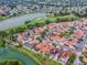 Stunning aerial view of a residential neighborhood with lake and golf course views and beautiful terracotta roofs at 903 Santa Anna Ln, Lady Lake, FL 32159