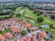 Picturesque aerial view of homes with screened-in pools nestled next to a beautifully designed golf course and ponds at 903 Santa Anna Ln, Lady Lake, FL 32159